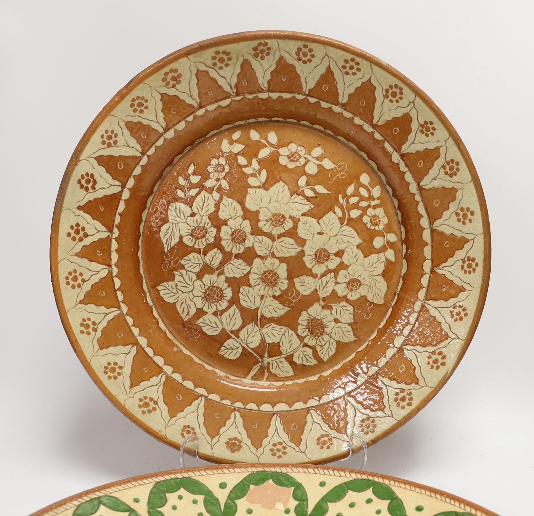 Two Portuguese glazed and incised pottery chargers, 36cm diameter